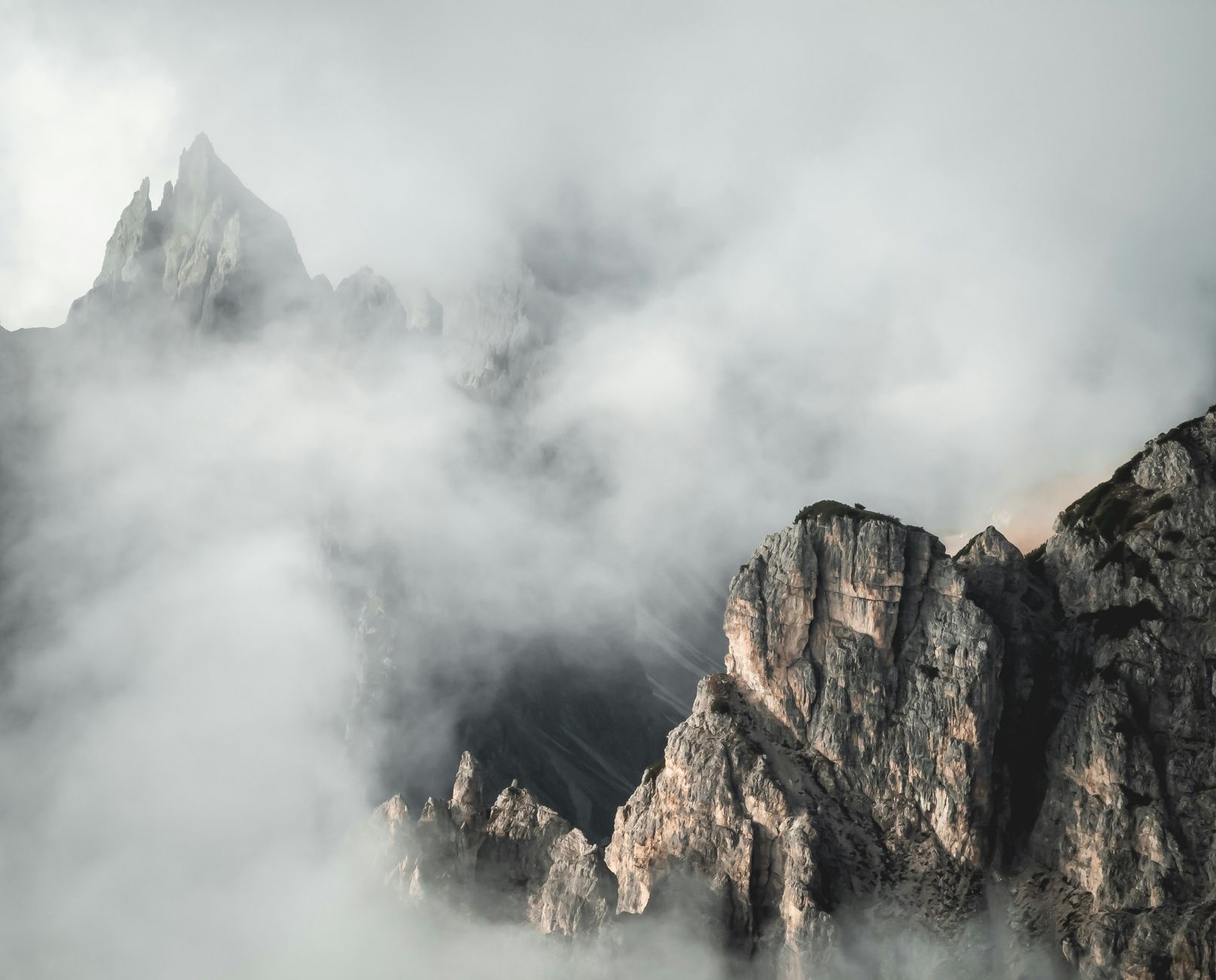 Quiet mist enveloping dramatic coastal peaks